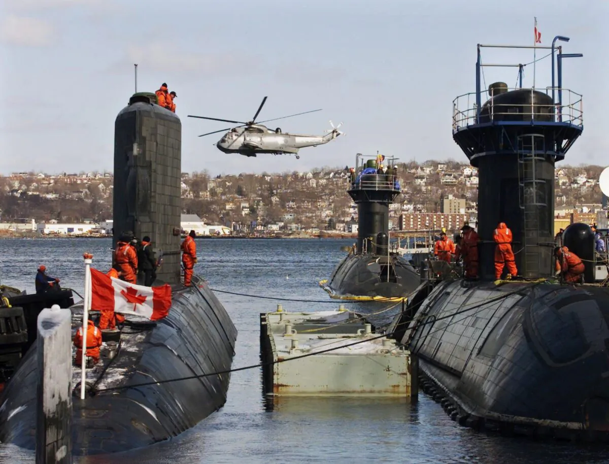 HMCS Corner Brook (L), the third of four used Victoria-class submarines leased from Britain, arrives in Halifax on March 10, 2003. On the right, HMCS Windsor and HMCS Victoria sit at berth. (CP PHOTO/Andrew Vaughan)