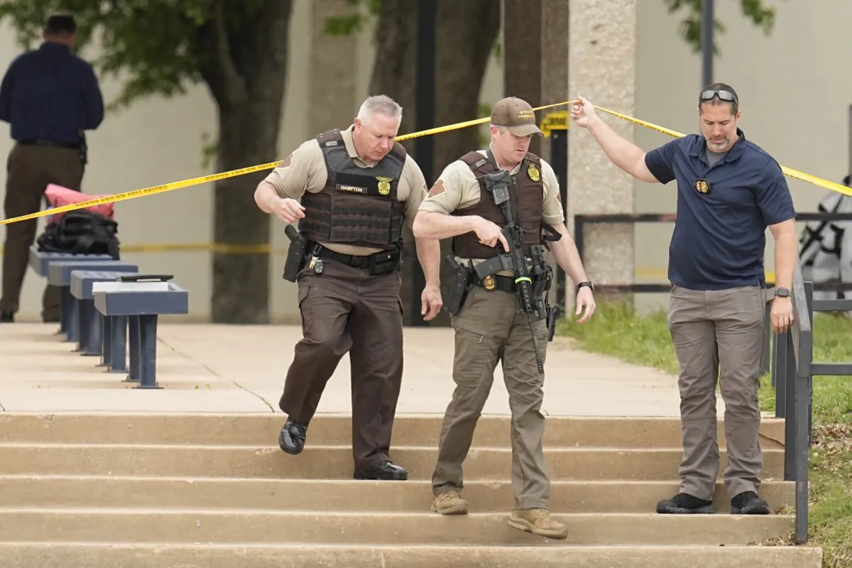 Oklahoma state troopers walk under police tape following a fatal shooting at Rose State College in Midwest City, Okla., on April 24, 2023. (Sue Ogrocki/AP Photo)