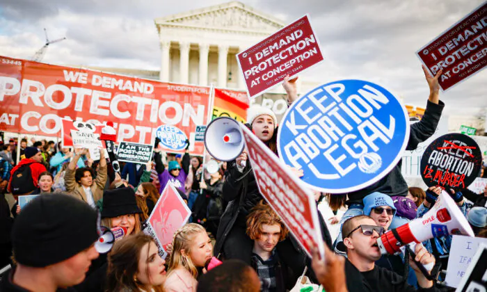 Pro-life and pro-abortion activists hold signs with opposing views during the 50th annual March for Life rally in front of the U.S. Supreme Court in Washington on Jan. 20, 2023. (Chip Somodevilla/Getty Images)