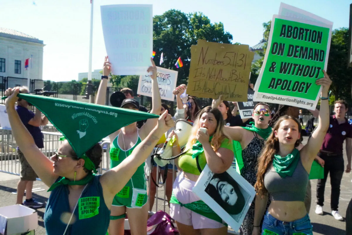 Pro-abortion protesters with Rise Up 4 Abortion Rights wear green as they protest outside the U.S. Supreme Court in Washington on June 15, 2022. (Jackson Elliott/The Epoch Times)