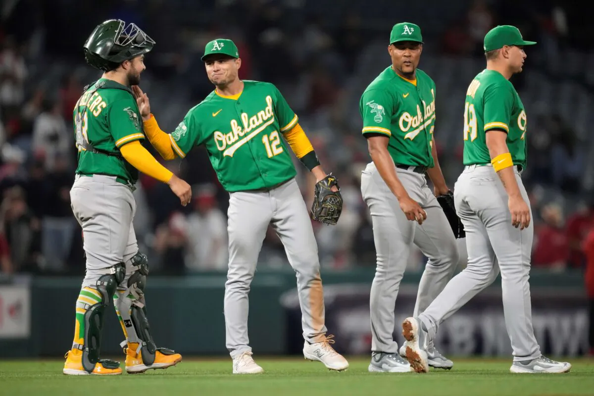 Oakland Athletics catcher Shea Langeliers (23), third baseman Aledmys Diaz (12), relief pitcher Jeurys Familia (31), and first baseman Ryan Noda (49) celebrate after an 11–10 win over the Los Angeles Angels in a baseball game in Anaheim, Calif., on April 24, 2023. (Ashley Landis/AP Photo)