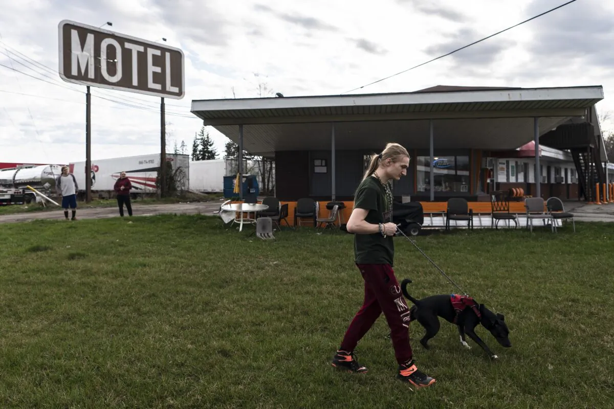 Kyan Cepin, who now resides in a motel after being displaced by the East Palestine train derailment walks his dog Opal in North Lima, Ohio, on April 3, 2023. (Matt Rourke/AP Photo)