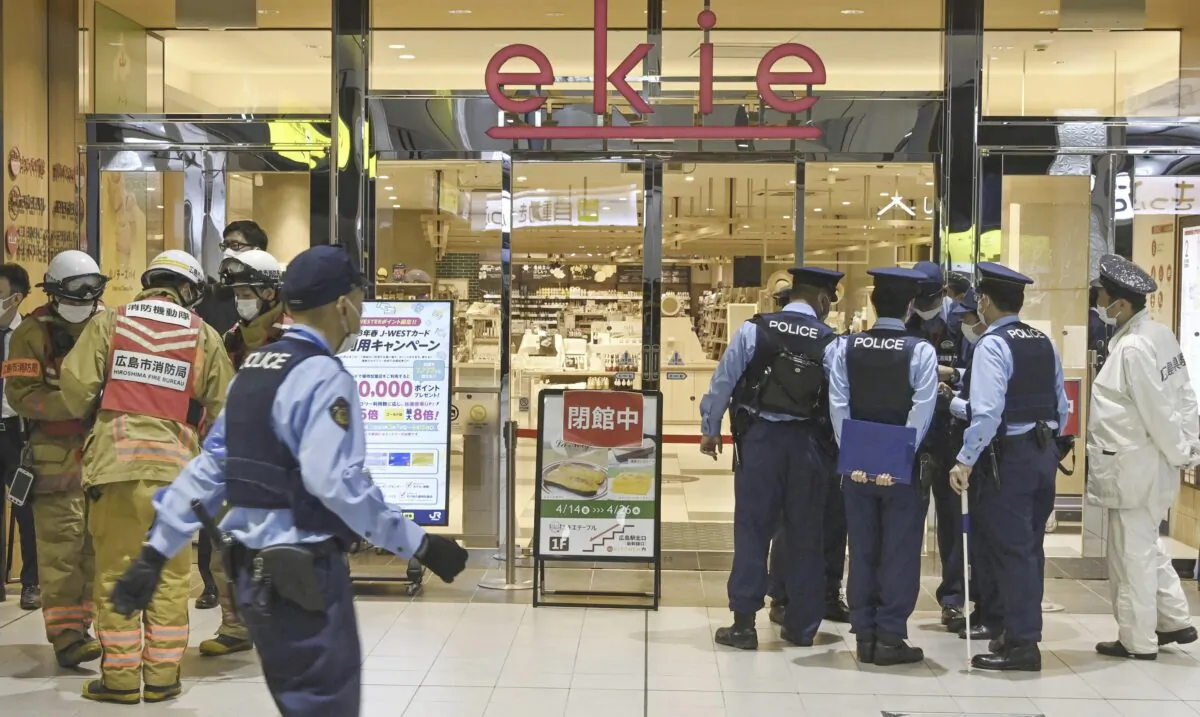 Police officers gather at the entrance of the commercial complex "ekie" where a suspicious object was found in Hiroshima, western Japan, on April 25, 2023. (Kyodo News via AP)