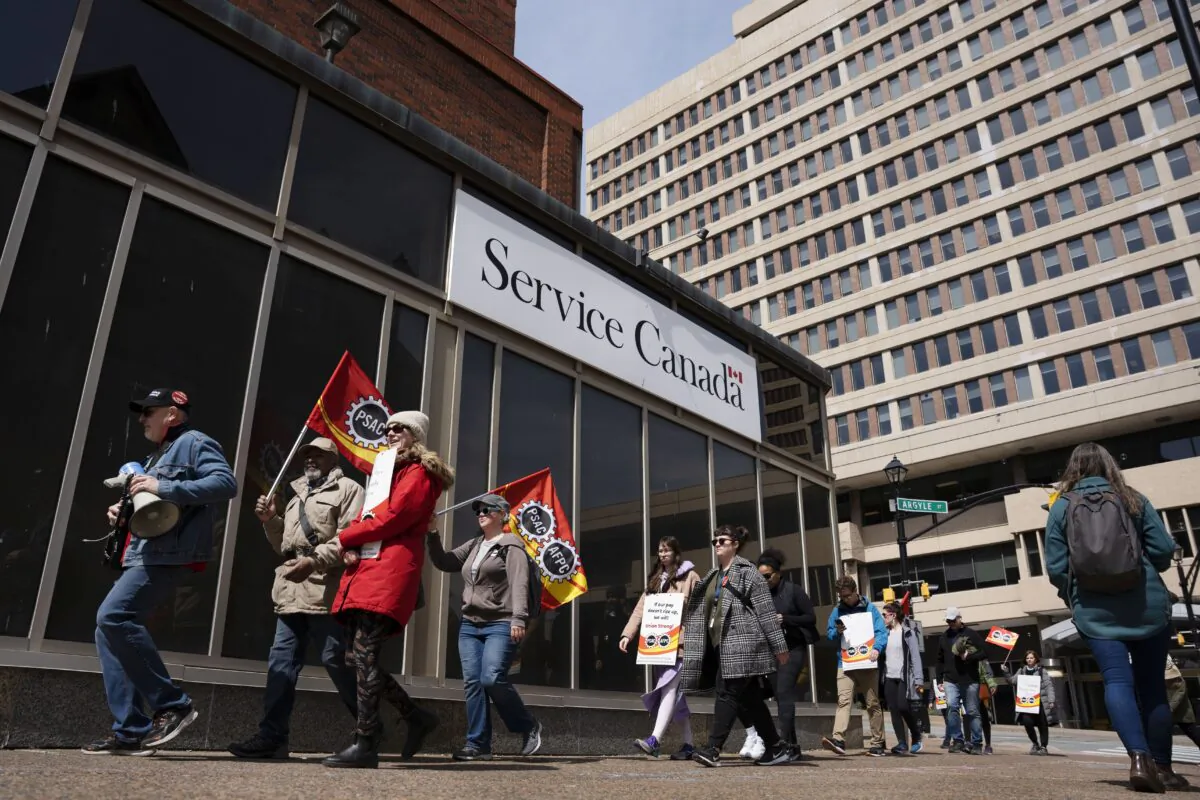 PSAC workers and supporters walk a picket line outside a Service Canada office in Halifax on April 24, 2023. (The Canadian Press/Darren Calabrese)