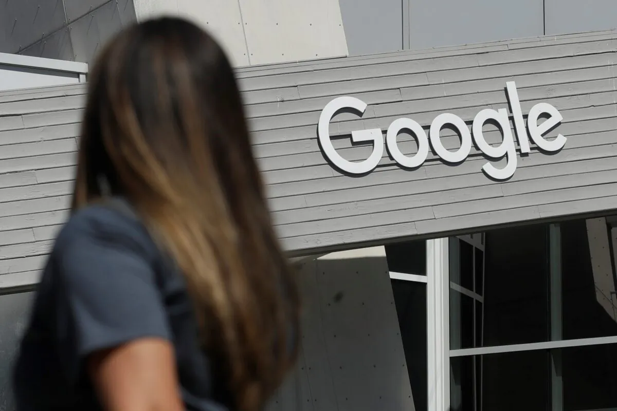 A woman walks below a Google sign on the campus in Mountain View, Calif., on Sept. 24, 2019. (Jeff Chiu/AP Photo)