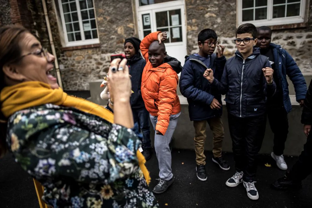Autistic children pose for a picture taken by a specialised teacher Caroline Berge (L) at the College du Parc in Aulnay-sous-Bois, northeast of Paris on October 9, 2019. (Photo by Christophe ARCHAMBAULT/AFP via Getty Images)