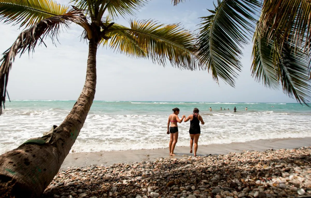 Tourists walk on the shore of the Raymond les bains beach in Jacmel, Haiti, on June 28, 2013. (Dieu Nalio Chery/AP Photo)