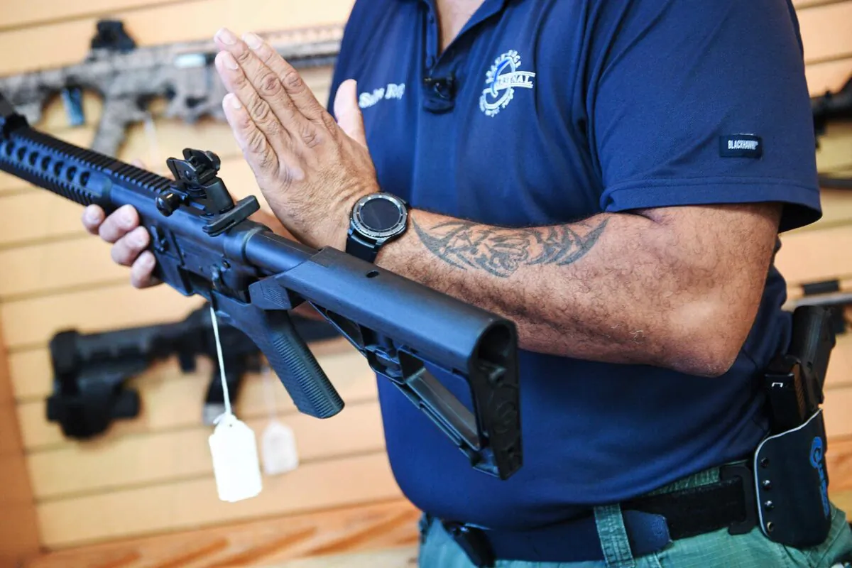 Senior Sales Staff Mark Warner shows a bump stock installed on an AR-15 rifle at Blue Ridge Arsenal in Chantilly, Virgina, on October 6, 2017. / AFP PHOTO / JIM WATSON (Photo credit should read JIM WATSON/AFP/Getty Images)