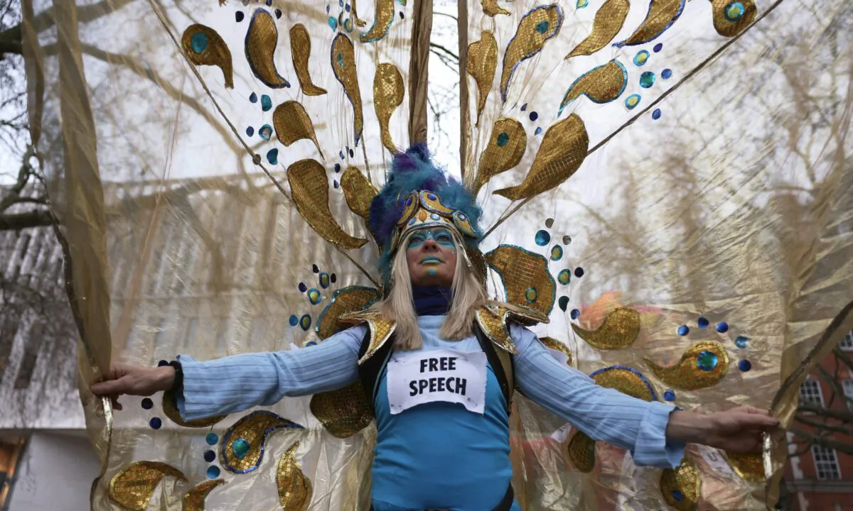 A woman dresses up in a costume with a sign saying "free speech" as she prepares to take part in a protest in Westminster, London, on Feb. 11, 2023. (Dan Kitwood/Getty Images)
