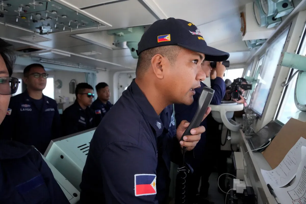 Philippine Coast Guard Petty Officer 3 John Solatre uses the radio on board the BRP Malabrigo to send a message to suspected Chinese militia ships near Philippine-claimed Island of Thitu, locally known as Pag-asa island, at the South China Sea on April 21, 2023. (Aaron Favila/AP Photo)