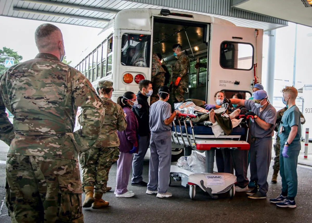 FILE PHOTO: U.S. Soldiers, Airmen and civilian staff receive casualties who were injured outside of Hamid Karzai International Airport and evacuated to the U.S. Army-operated Landstuhl Regional Medical Center (LRMC) for further care in Landstuhl, Germany August 27, 2021. Landstuhl Regional Medical Center/Marcy Sanchez/Handout via REUTERS