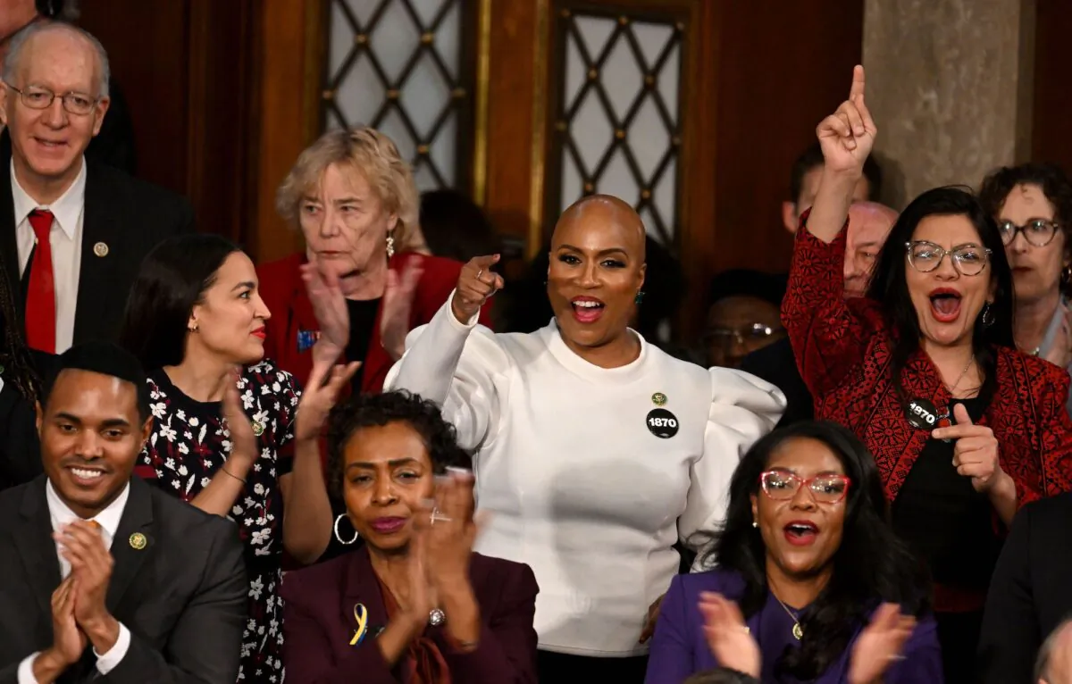 (L-R) Reps. Alexandria Ocasio-Cortez (D-N.Y.), Ayanna Pressley (D-Mass.), and Rashida Harbi Tlaib (D-Mich.) cheer as U.S. President Joe Biden delivers the State of the Union address in the House Chamber of the U.S. Capitol in Washington, on Feb. 7, 2023. (Jim Watson/AFP via Getty Images)