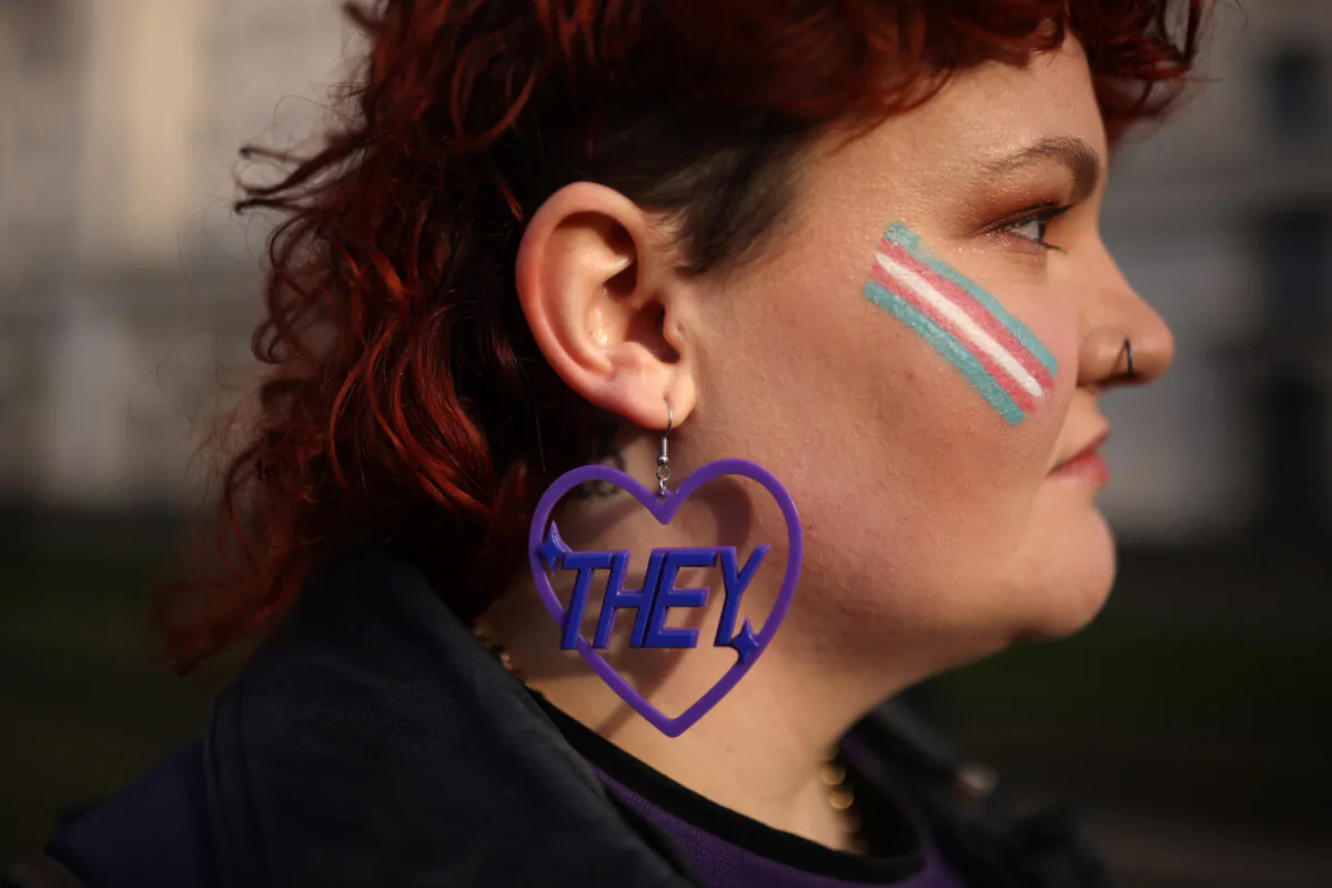A trans activist wears an earring featuring a "they" pronoun symbol, during a protest outside the Ministry of Defence Main Building in Whitehall in London, on Jan. 17, 2023. (Dan Kitwood/Getty Images)