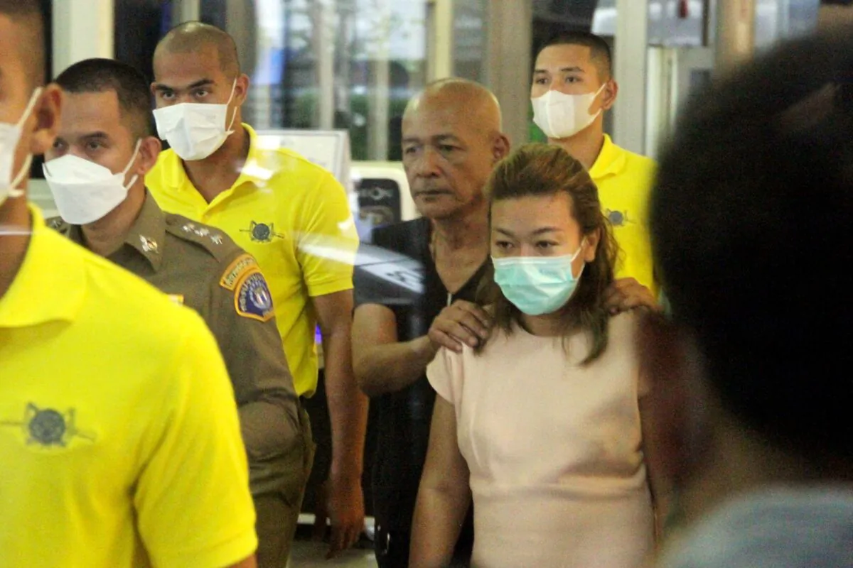 Sararat Rangsiwuthaporn, a suspect in over a dozen murders, is escorted by police officers at a police station in Bangkok, Thailand, on April 26, 2023. (Daily News Handout via Reuters)