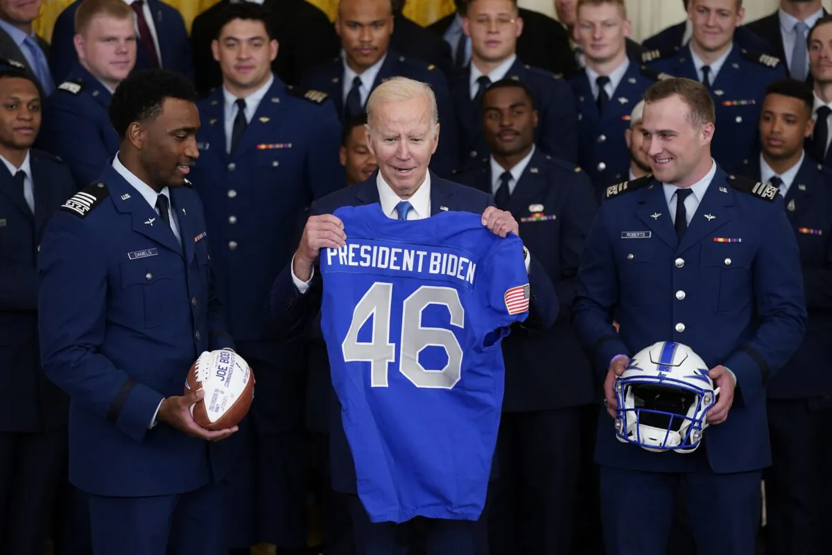 Air Force quarterback Haaziq Daniels (L) and Air Force running back Brad Roberts (R) present President Joe Biden with a jersey during the presentation of the Commander-in-Chief's trophy to the Air Force Academy in the East Room of the White House on April 28, 2023. (Evan Vucci/AP Photo)