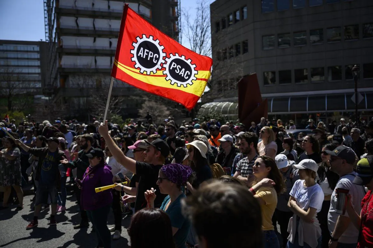 Members of the Public Service Alliance of Canada watch a performance as they picket outside Place du Portage in Gatineau, Que., on April 28, 2023. (The Canadian Press/Justin Tang)