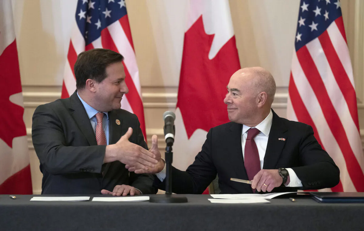 Public Safety Minister Marco Mendicino and U.S. Secretary of Homeland Security Alejandro Mayorkas shake hands after signing an agreement following the conclusion of the 2023 Canada-United States Cross-Border Crime Forum, in Ottawa on April 28, 2023. (Adrian Wyld/The Canadian Press via AP)