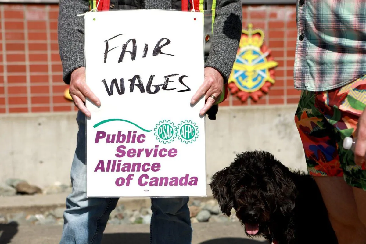 PSAC workers walk the picket line out front of His Majesty's Canadian Dockyard in Esquimalt, B.C., on April 28, 2023. (The Canadian Press/Chad Hipolito)
