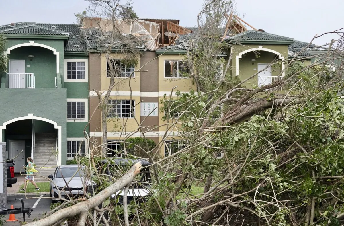 Downed trees appear near a property with a damaged roof after a reported tornado hit the area in Palm Beach Gardens, Fla., on April 30, 2023. (Joe Cavaretta/South Florida Sun-Sentinel via AP)