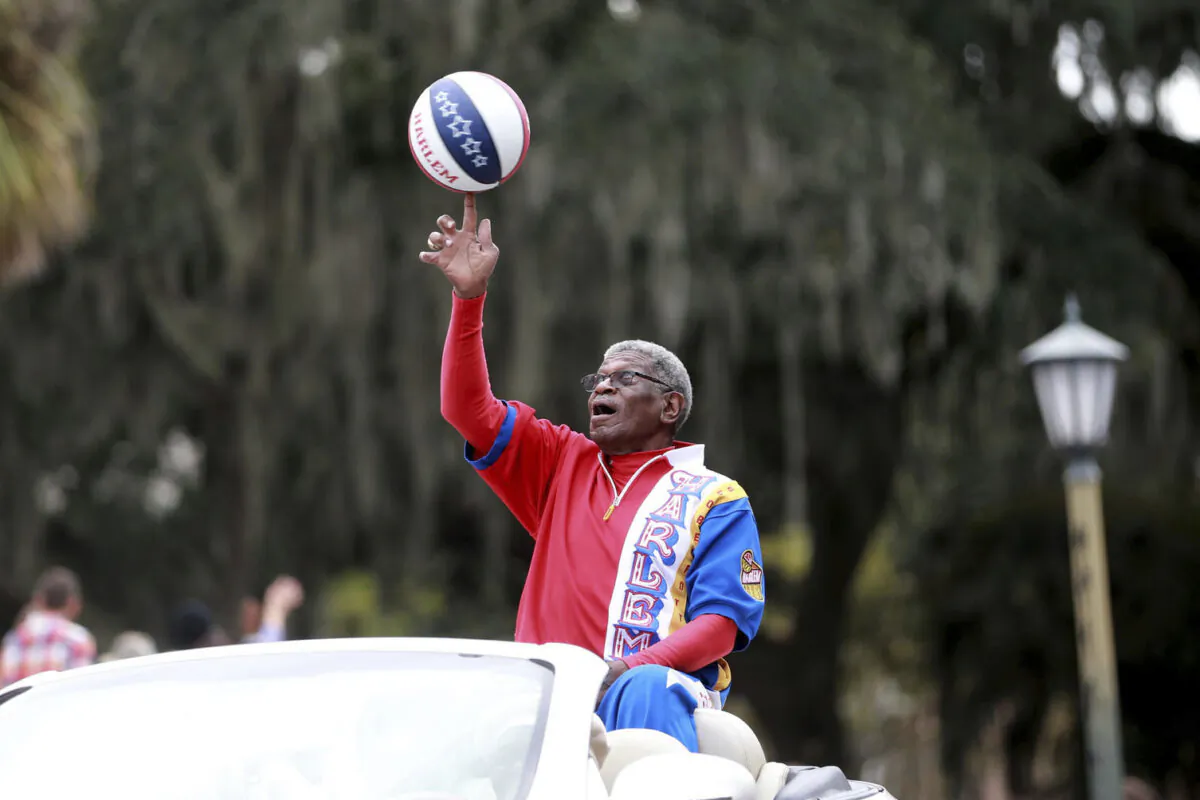 Larry "Gator" Rivers, a member of the Chatham County Commission and a former Harlem Globetrotter, shows off his ball handling skills as he rides in the annual Veterans Day Parade in Savannah, Ga., on Nov. 11, 2021. (Richard Burkhart/Savannah Morning News via AP)