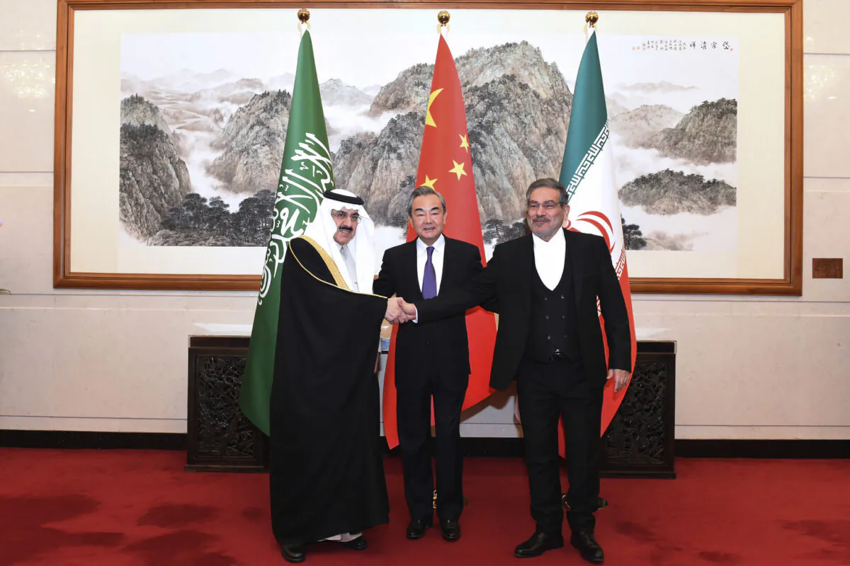 Ali Shamkhani, the secretary of Iran's Supreme National Security Council (R) shakes hands with Saudi's national security adviser, Musaad bin Mohammed al-Aiban (L), as Wang Yi, China's most senior diplomat, looks on. (Luo Xiaoguang/AP Photo)