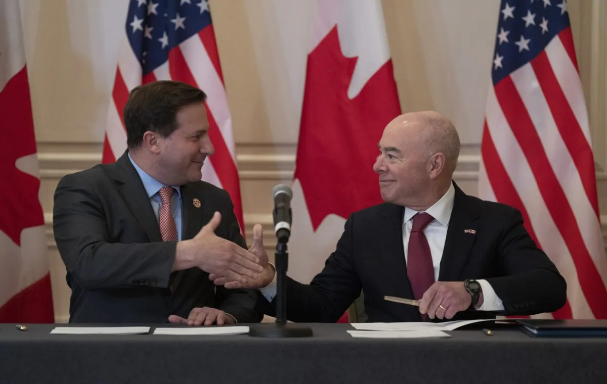 Public Safety Minister Marco Mendicino and U.S. Secretary of Homeland Security Alejandro Mayorkas shake hands after signing an agreement following the conclusion of the 2023 Canada-United States Cross-Border Crime Forum in Ottawa on April 28, 2023. (The Canadian Press/Adrian Wyld)