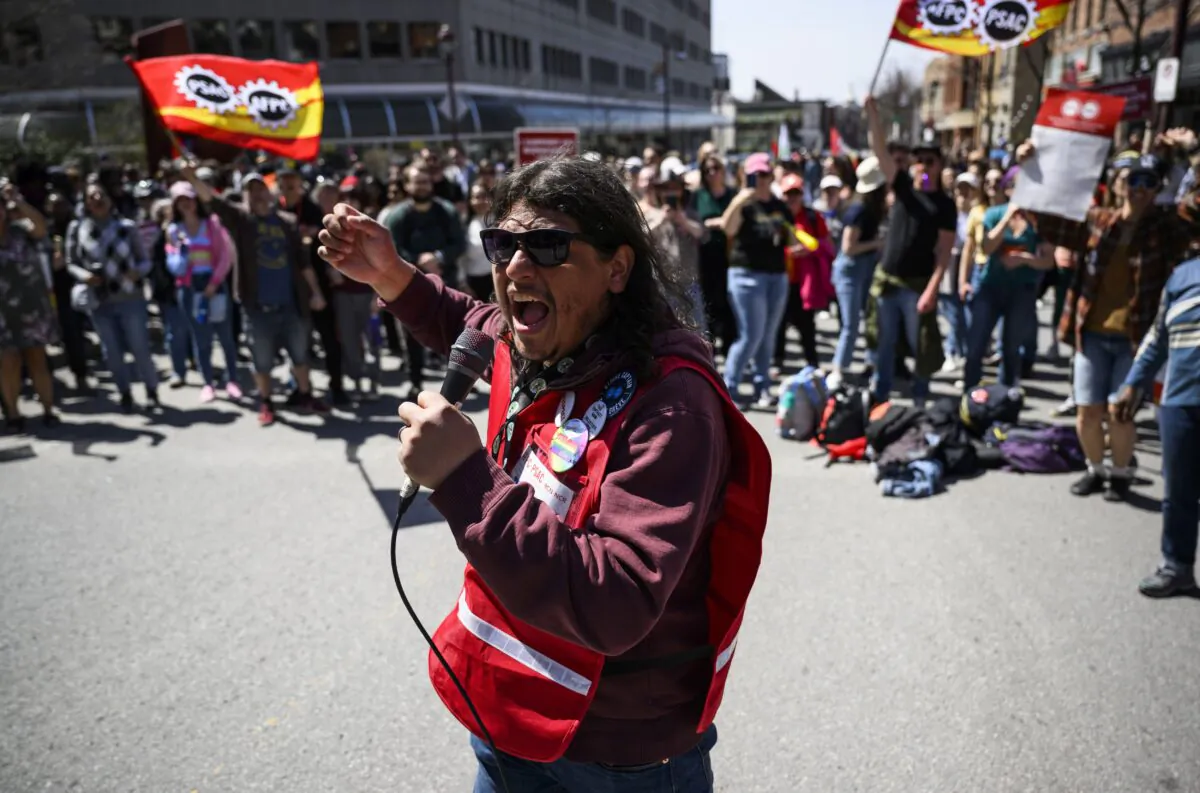 A strike captain leads members of the Public Service Alliance of Canada in a chant as they picket outside Place du Portage in Gatineau, Que., on April 28, 2023. (The Canadian Press/Justin Tang)

