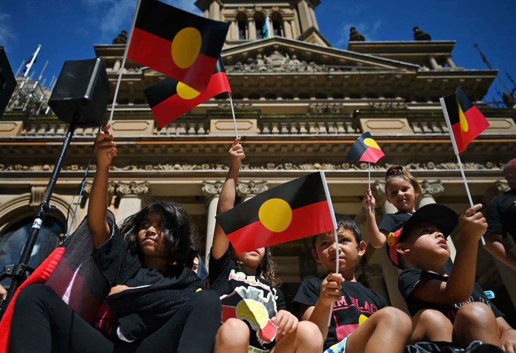 Youths and children wave the Australian aboriginal flag as protesters take part in an "Invasion Day" demonstration on Australia Day in Sydney on Jan. 26, 2022. (Steven Saphore/AFP via Getty Images)