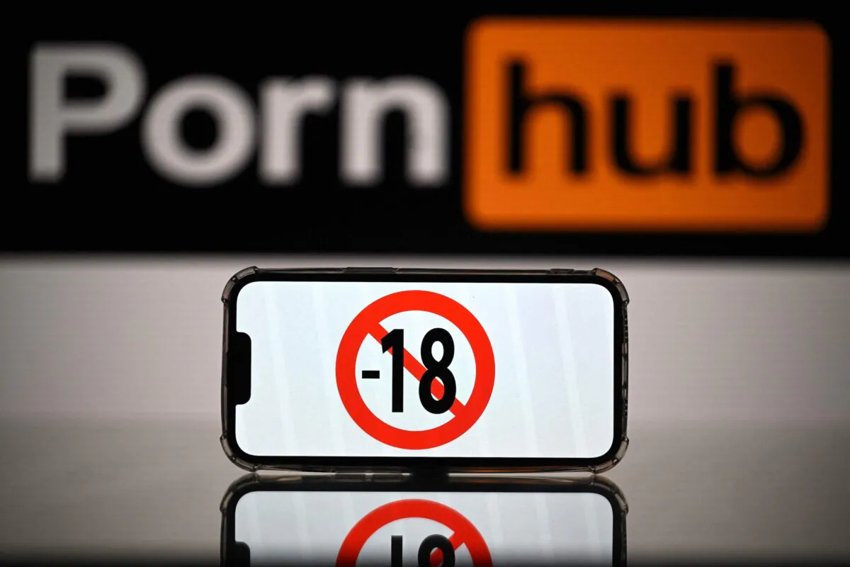 A screen displays a “no under-18s” sign in front of the logo of a pornographic website as regulators consider requiring such sites to ensure they are preventing minors from being exposed to their content. (Lionel Bonaventure/AFP via Getty Images)