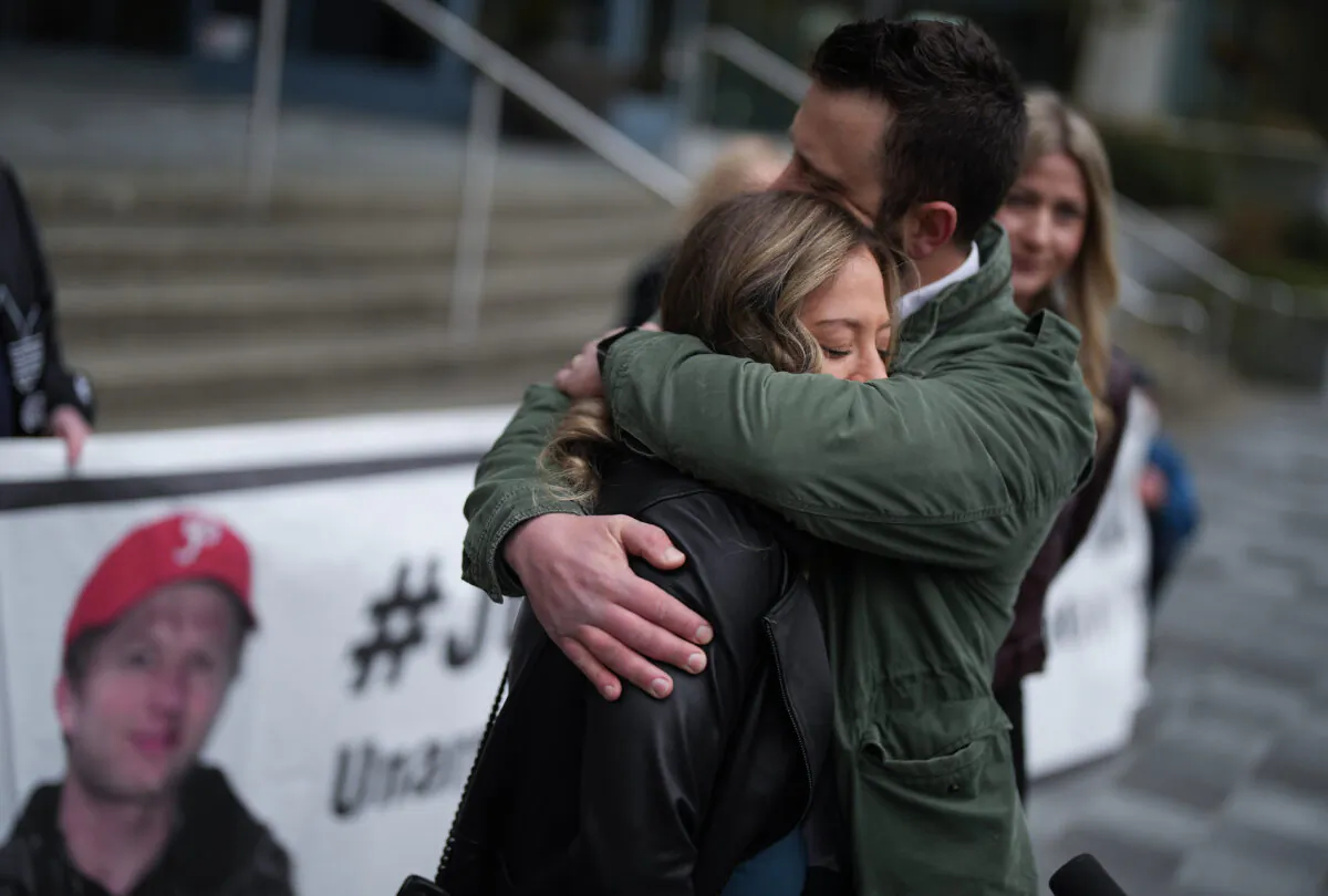 Melissa Gray (L) is embraced by her husband Mike Easson after speaking about her brother, Myles Gray, who died following a confrontation with several police officers in 2015, before the start of a coroner's inquest into his death, in Burnaby, B.C., on April 17, 2023. (The Canadian Press/Darryl Dyck)