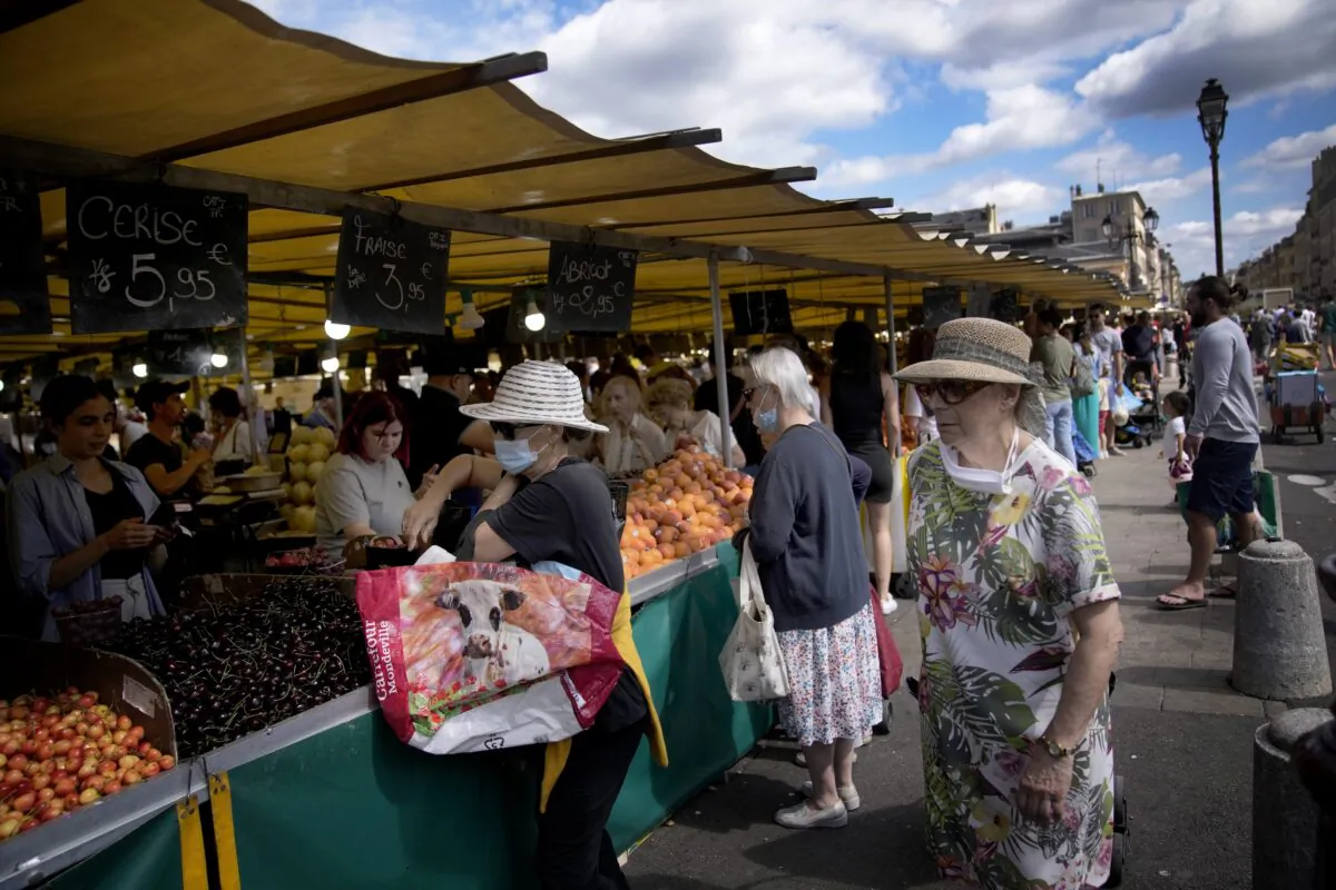 People shop at a market in Versailles, outside Paris on July 3, 2022. (Christophe Ena/AP Photo)