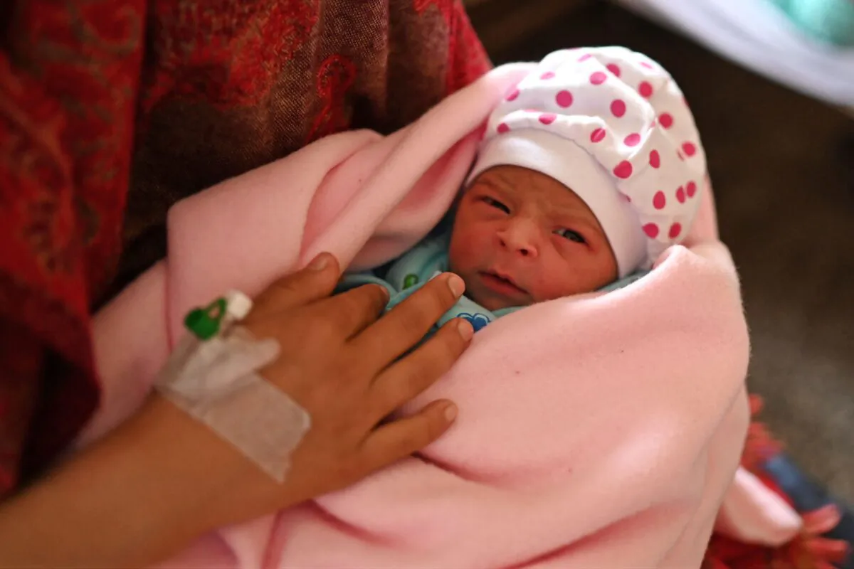 A woman holds her newborn daughter at a hospital in Dehra, India, on April 25, 2023. (Money Sharma/AFP via Getty Images)
