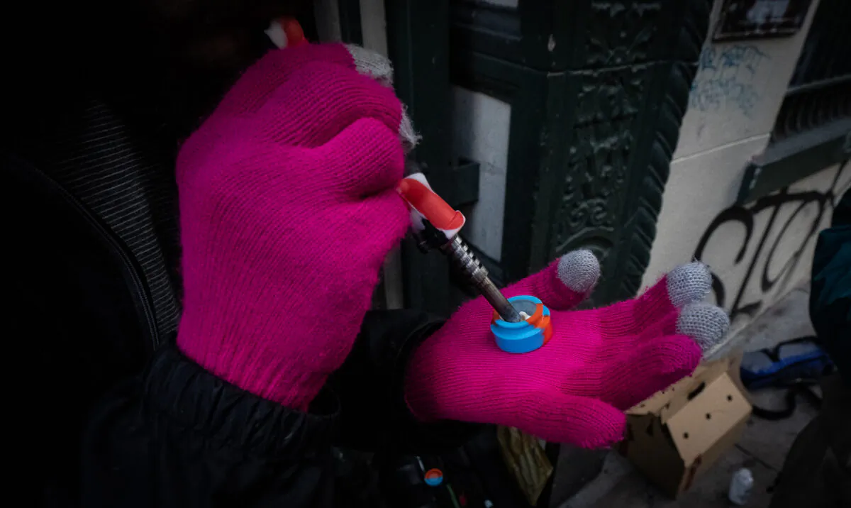 A man prepares to heat fentanyl in San Francisco on Feb. 22, 2023. (John Fredricks/The Epoch Times)