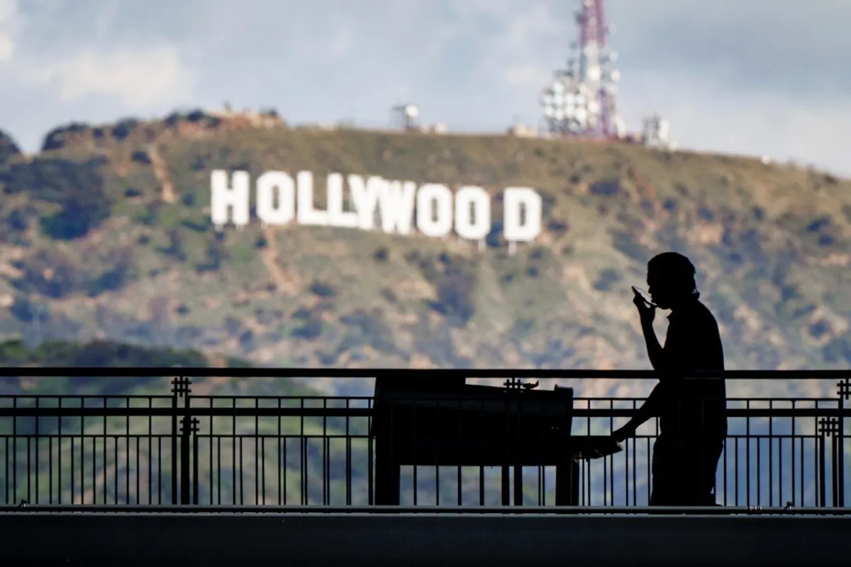 A worker wheels equipment past the famous Hollywood sign as preparations continue for the 95th Academy Awards at the Dolby Theatre in Los Angeles, on March 8, 2023. (J. David Ake/AP Photo)
