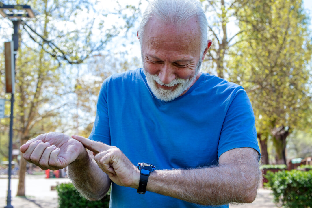 A man checks his pulse after training in the park.