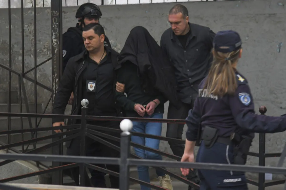 A suspect is escorted by police outside the Vladislav Ribnikar school in Belgrade, Serbia, on May 3, 2023. (AP Photo)