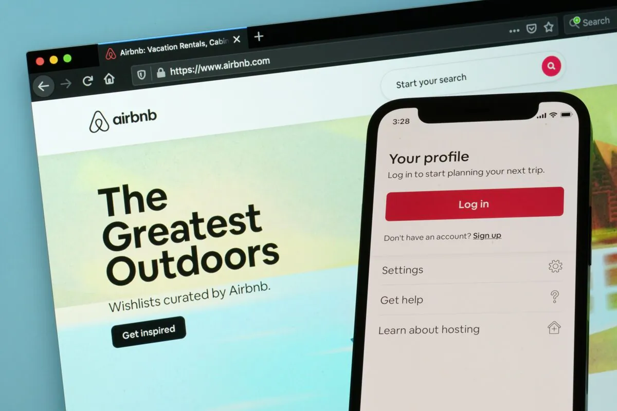 The login page for Airbnb's iPhone app is seen in front of a computer displaying Airbnb's website in Washington on May 8, 2021. (Patrick Semansky/AP Photo)