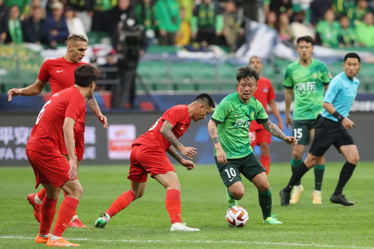 Beijing Guoan's Zhang Xizhe (C) fights for the ball during their Chinese Super League football match (CSL) with Meizhou Hakka FC at the Workers' Stadium in Beijing on April 15, 2023. (STR/AFP via Getty Images)