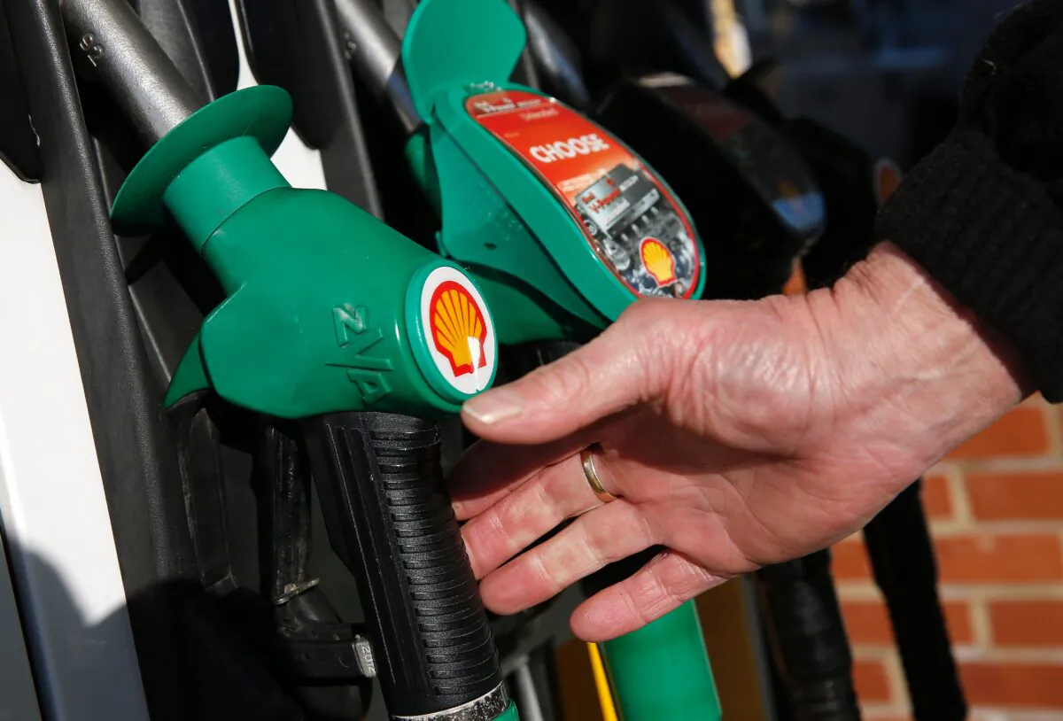 A man reaches for an unleaded petrol nozzle at a Shell fuel station near Basingstoke in England on Jan. 20, 2016. (Adrian Dennis/AFP via Getty Images)