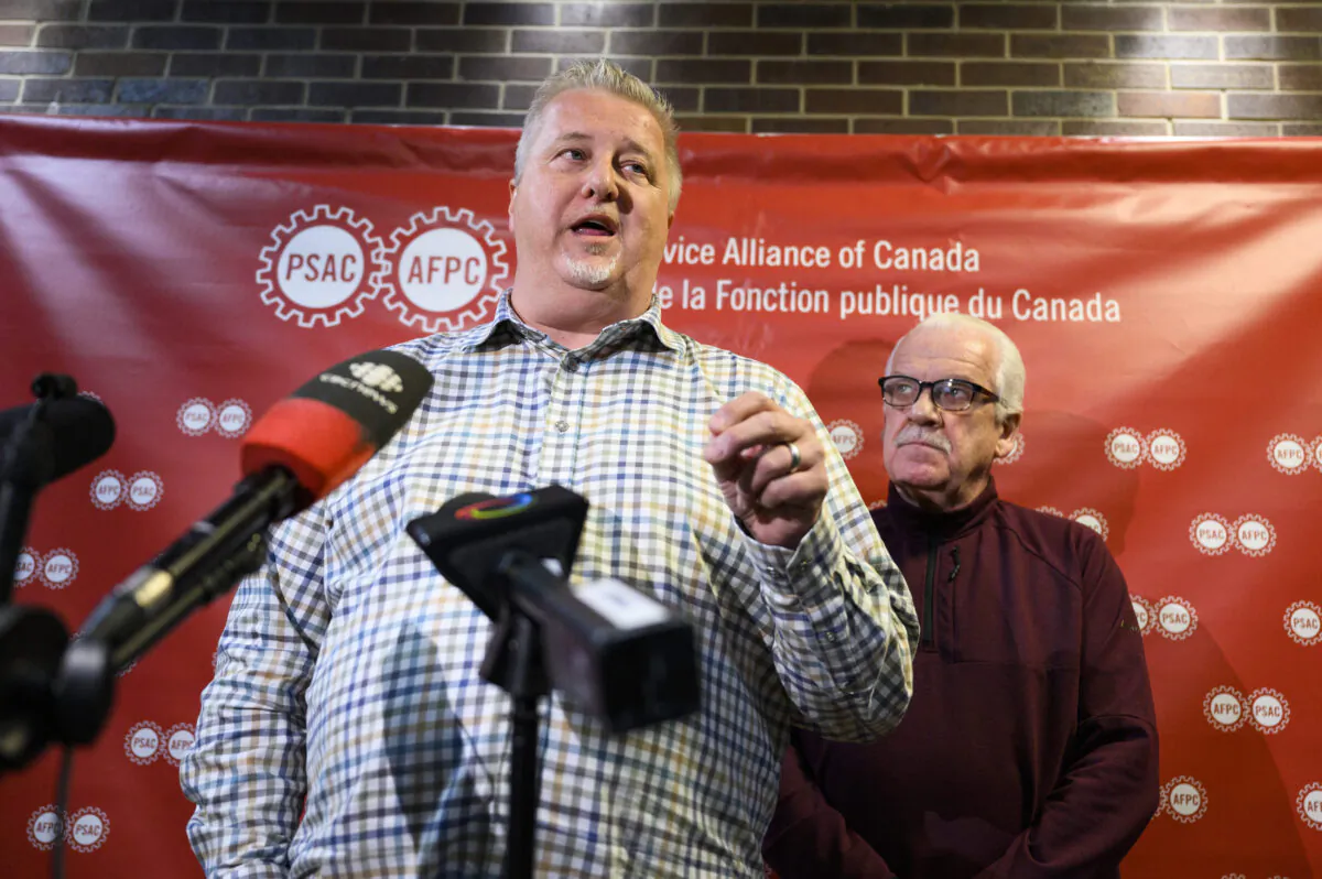 Marc Briere, National President of the Union of Taxation Employees, participates in a news conference as Chris Aylward, PSAC national President looks on, on the negotiations with Canada Revenue Agency, as PSAC-UTE members, who comprise a component of the Public Service Alliance of Canada (PSAC), remain on strike, in Ottawa, on May 3, 2023. (THE CANADIAN PRESS/Justin Tang)