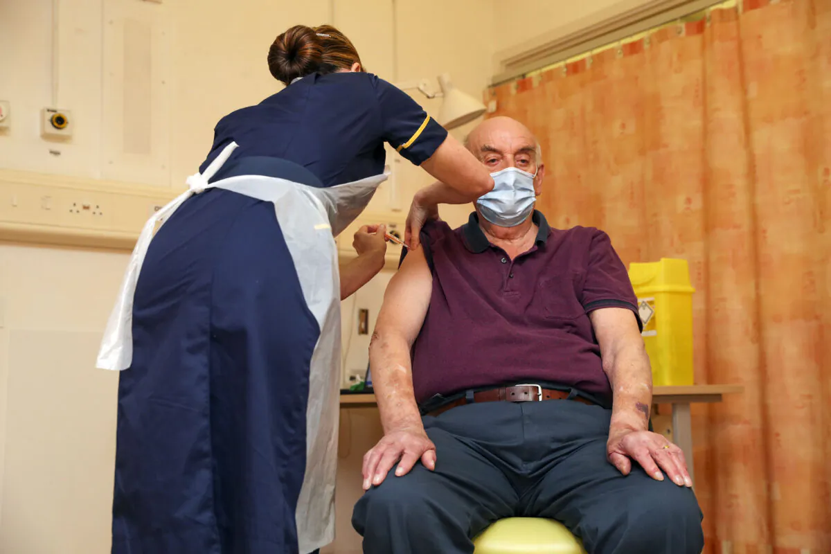 Brian Pinker, 82, receives the Oxford University/AstraZeneca COVID-19 vaccine from nurse Sam Foster at the Churchill Hospital in Oxford, England, on Jan. 4, 2021. (Steve Parsons—WPA Pool/Getty Images)