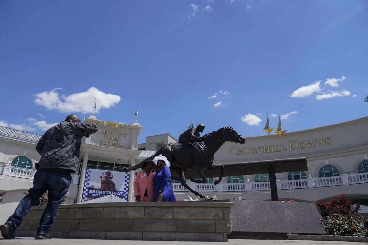 Race fans take photos in front of a statue of Barbaro at Churchill Downs in Louisville, Ky., on May 4, 2023. (Kiichiro Sato/AP Photo)