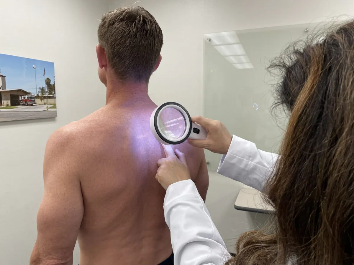 Dr. Tanya Evans from CalDerm is seen performing skin cancer spot screening on a firefighter in Huntington Beach, Calif., on April 30, 2023. (Sophie Li/The Epoch Times)
