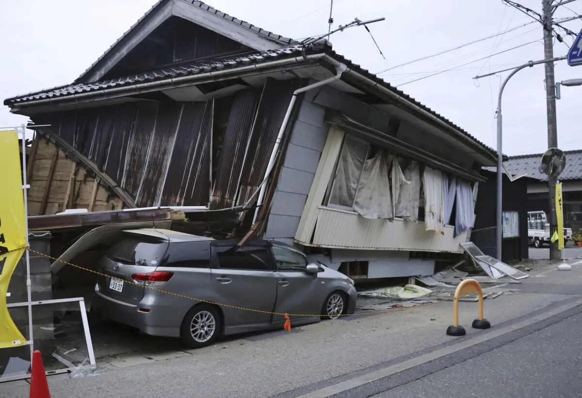 A car is crushed by a collapsed house after a strong earthquake in Suzu city, Ishikawa prefecture, northern Japan, on May 5, 2023. (Kyodo News via AP)