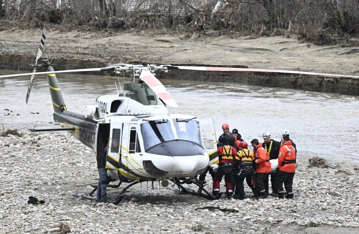 Rescuers carry the body of one of the two missing firefighters to a helicopter, May 3, 2023 in Baie-Saint-Paul, Que. (The Canadian Press/Jacques Boissinot)
