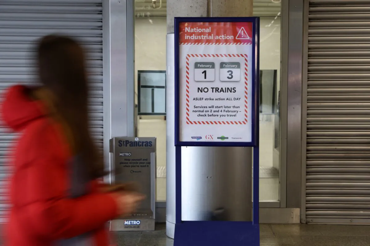 A commuter walks past a board informing passengers of this week's rail strike at Saint Pancras train station in London on February 3, 2023. - Railway commuters across England faced travel misery as train drivers staged their second stoppage over pay this week, the latest in a wave of UK industrial action. Millions of people were forced to make alternative travel plans or work from home as the majority of train companies on the country's fragmented network said they were running no services. (Photo by ISABEL INFANTES / AFP) (Photo by ISABEL INFANTES/AFP via Getty Images)