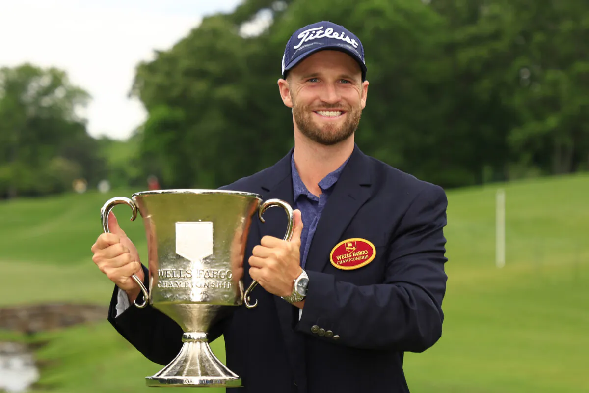 Wyndham Clark of the United States celebrates with the trophy after winning during the final round of the Wells Fargo Championship at Quail Hollow Country Club in Charlotte, on May 7, 2023. (Mike Ehrmann/Getty Images)