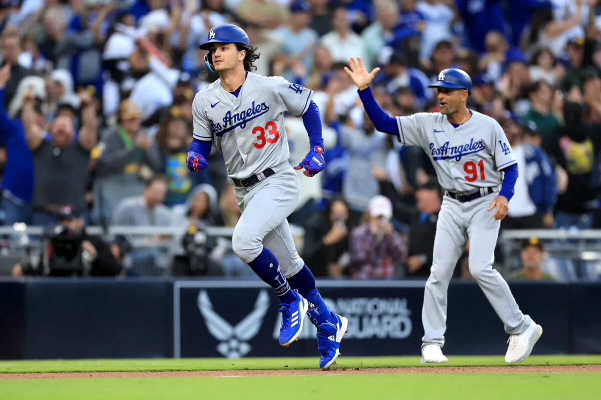 Third base coach Dino Ebel (91) celebrates as James Outman (33) of the Los Angeles Dodgers rounds third base after hitting a two-run home-run during the tenth inning of a game against the San Diego Padres at PETCO Park in San Diego on May 7, 2023. (Sean M. Haffey/Getty Images)
