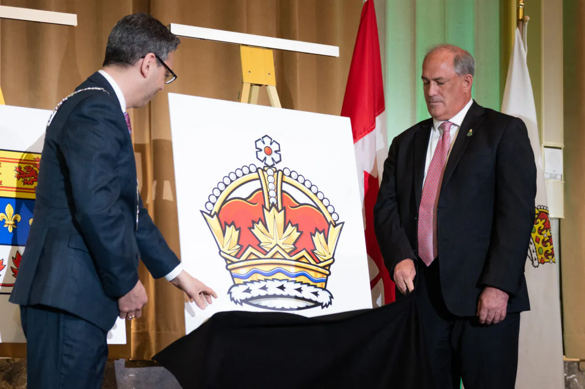 The Royal crown is unveiled by Samy Khalid (L), Chief Herald of Canada at the Canadian Heraldic Authority and Donald Booth, Canadian Secretary to the King, during coronation celebrations in honour of King Charles III in Ottawa on May 6, 2023. (The Canadian Press/Spencer Colby)