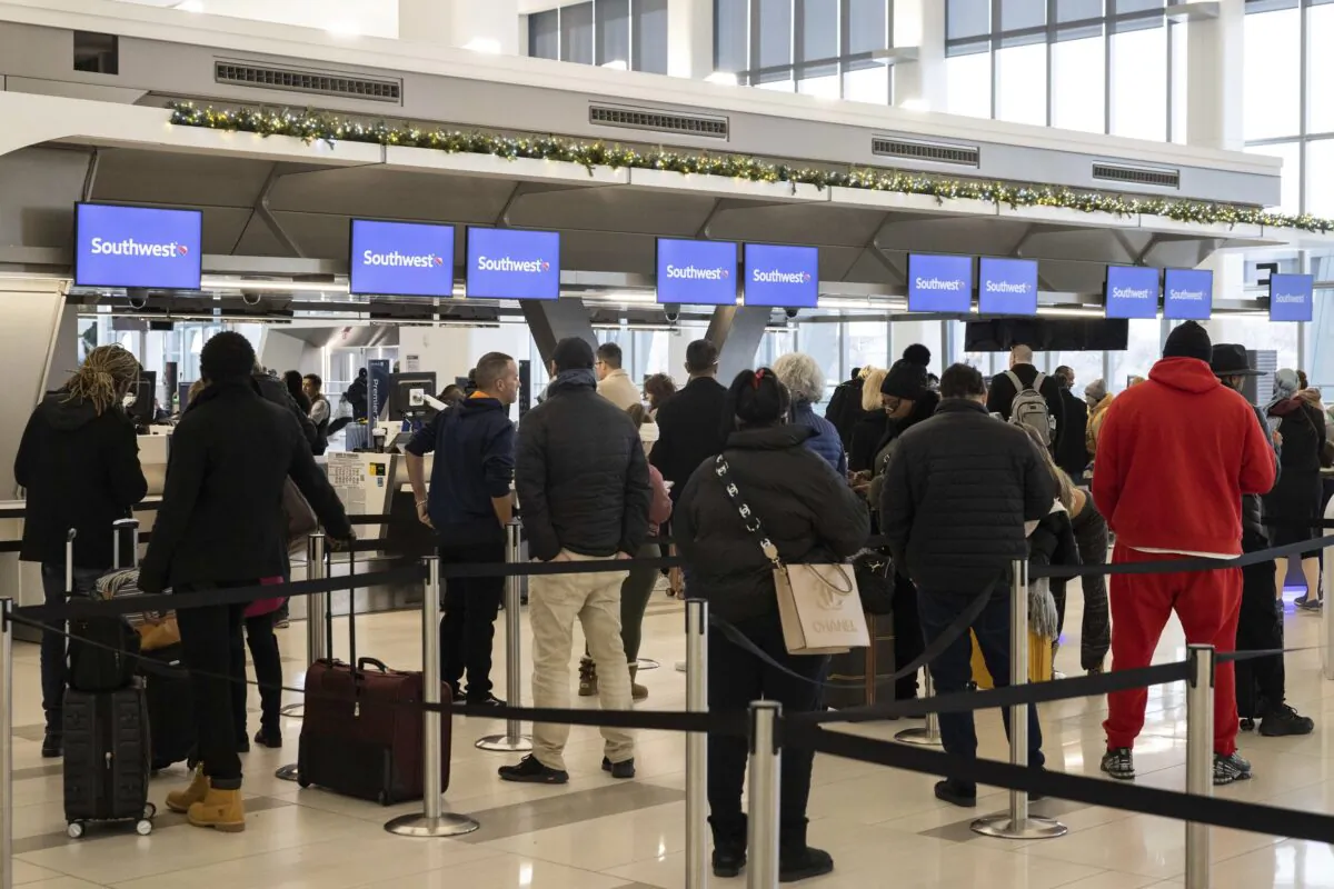 Passengers wait in line to check in for their flights at the Southwest Airlines service desk at LaGuardia Airport in New York on Dec. 27, 2022. (Yuki Iwamura/AP Photo)